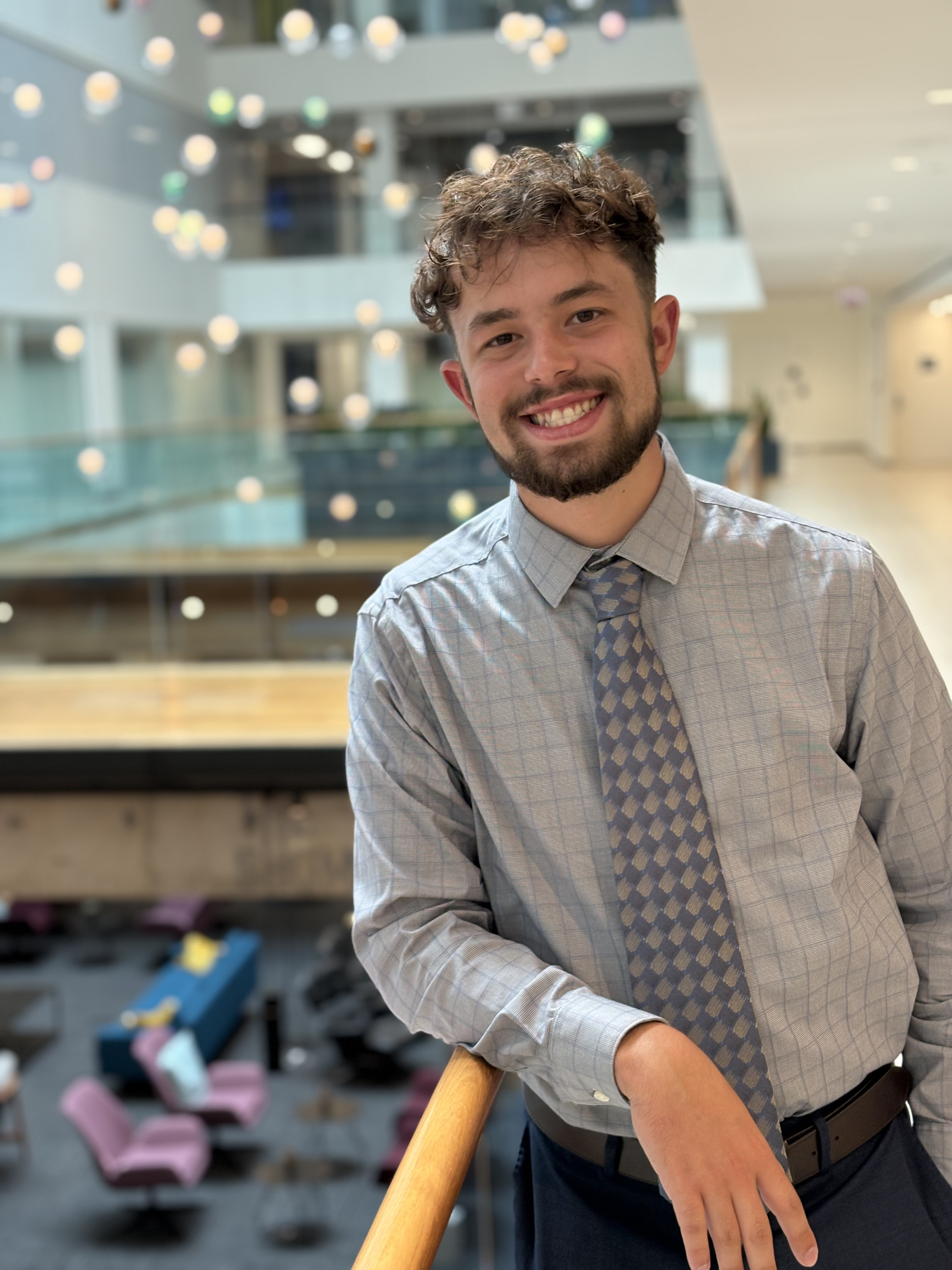 image of me leaning on railing inside an office building